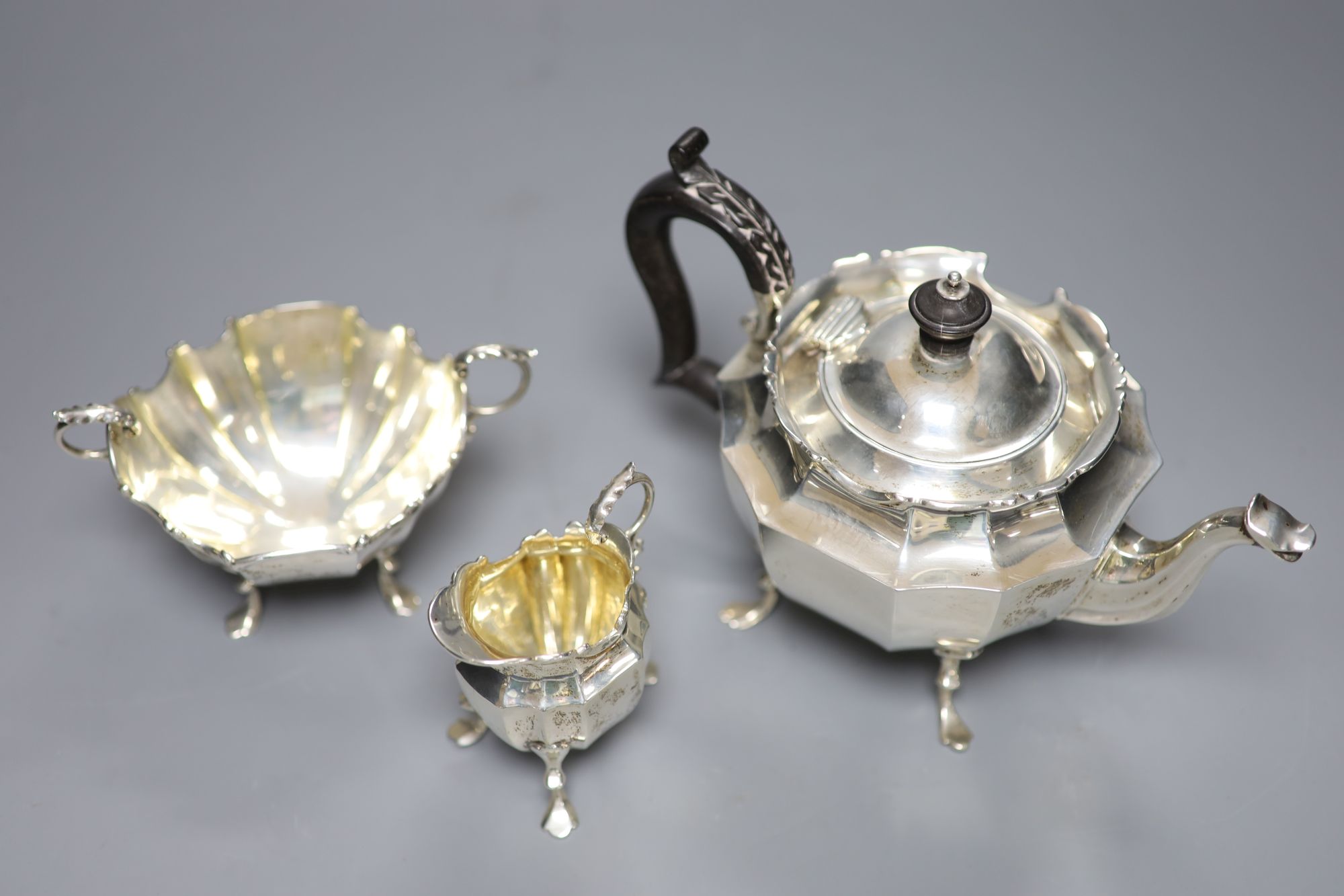 A late Victorian three-piece silver tea service of shaped stylised outline, J. R. Ltd, Birmingham 1898, gross 16.16oz